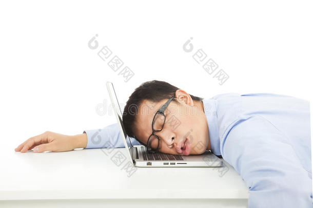 <strong>疲劳过度</strong>工作的商人睡在笔记本电脑上