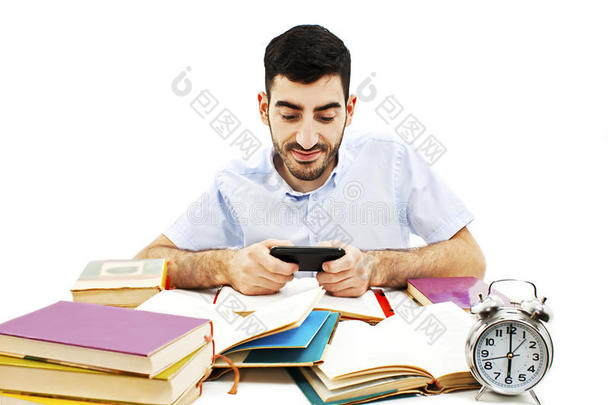 微笑的年轻人在<strong>手机</strong>上看短信而不是做作业