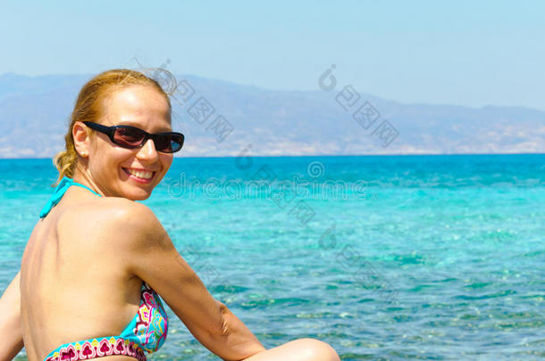 穿着<strong>泳装</strong>的美丽年轻女子，在热带阳光明媚的<strong>海滩</strong>上放松
