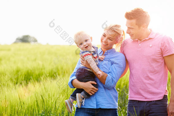 一家人抱着年幼的儿子在田里散步