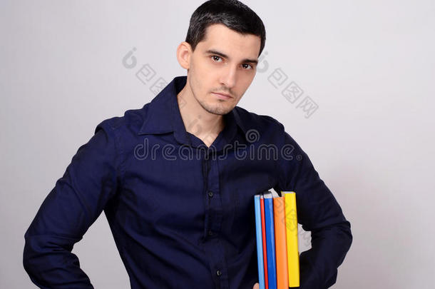 那个学生腋下夹着一堆书。老师手里拿着五颜六色的书。