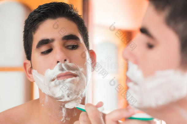 年轻的西班牙裔男子刮胡子
