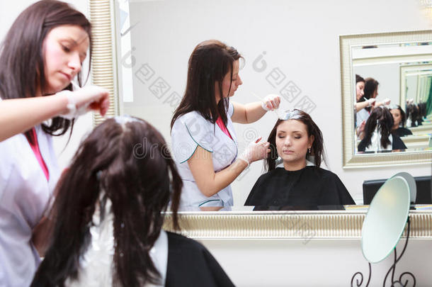 美发师在美容院为女顾客上色，做染发剂