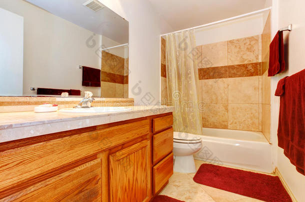 暖色浴室，带红色毛巾和地毯