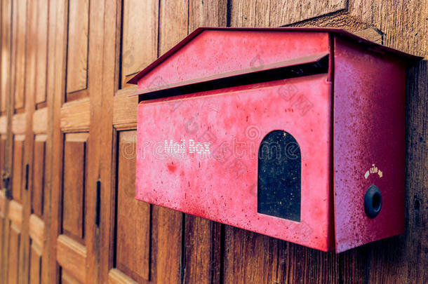 木质背景上的旧红色邮箱