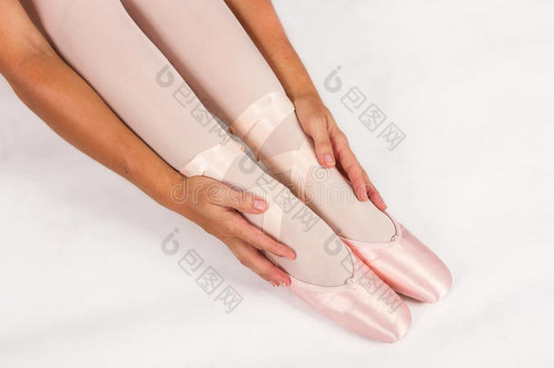 芭蕾舞演员坐在地板上穿拖鞋准备表演