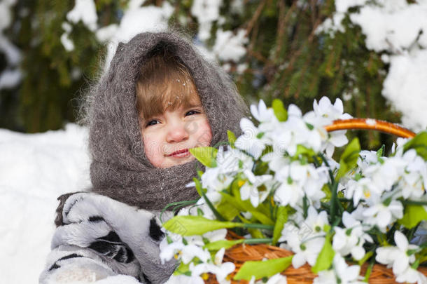 小女孩在冬日的树林里拿着一大筐雪水