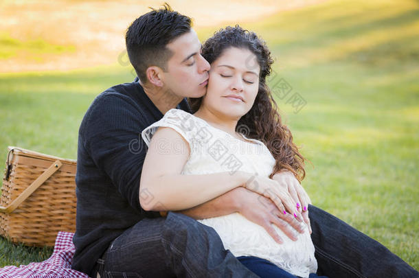 深<strong>情怀</strong>孕的西班牙裔夫妇在户外公园接吻