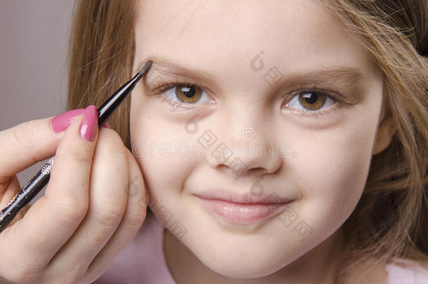 化妆师在女孩脸上画眉毛