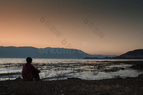 男人坐在洱海边