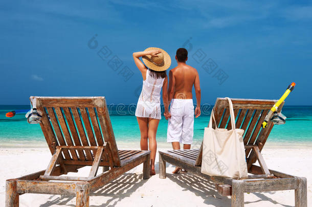 马尔代夫海滩上的一对白衣夫妇