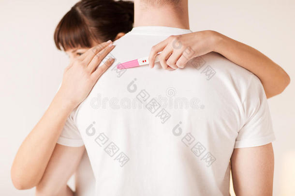 怀孕测试的女人拥抱男人