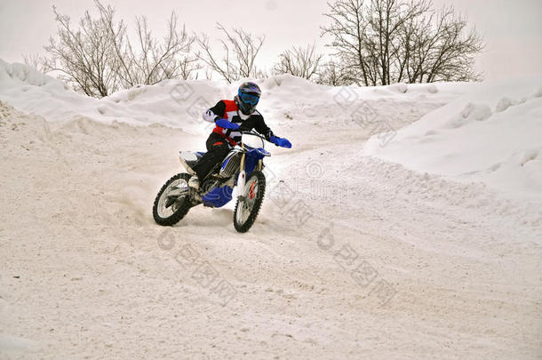 冬季摩托车越野赛车手在斜坡上转弯