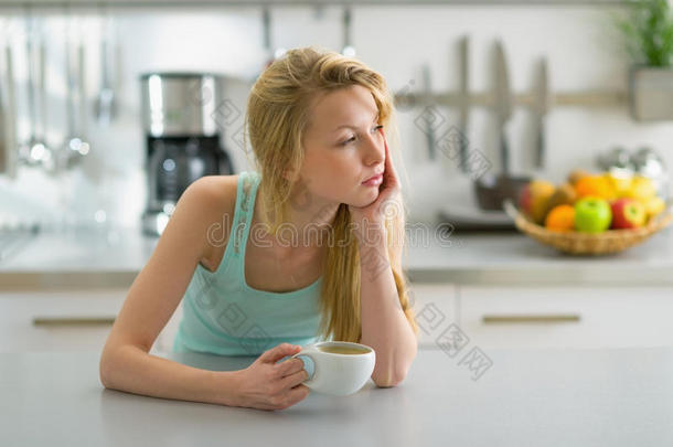 睡后在厨房喝咖啡的女人