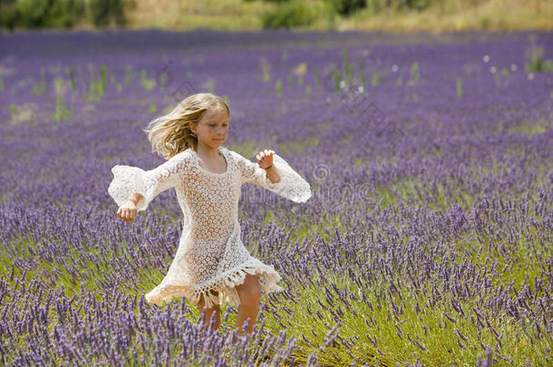 美丽的小女孩在紫色的薰衣草地里奔跑跳跃