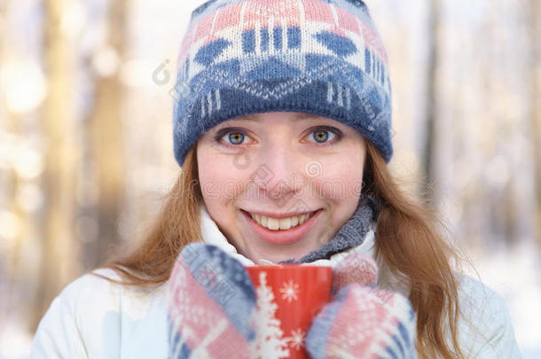 冬天的户外活动。年轻女子喝茶。
