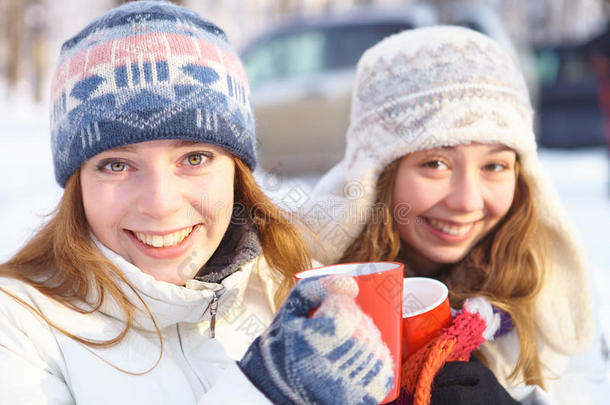 冬天的户外活动。女孩们喝茶。