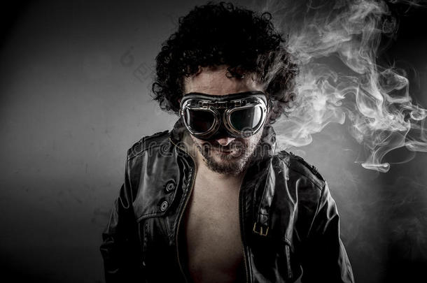 火辣辣的，戴着太阳镜的摩托车手穿的皮夹克，黑色背景下浓烟弥漫