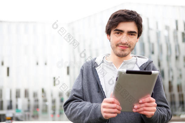 年轻放松的男人在街上用平板电脑