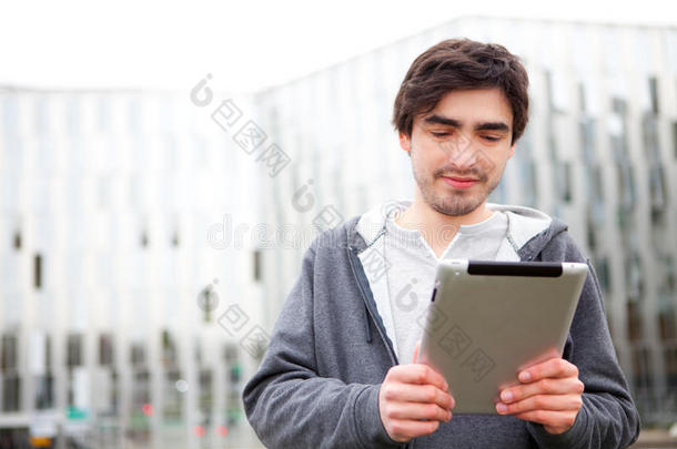 年<strong>轻放</strong>松的男人在街上用平板电脑