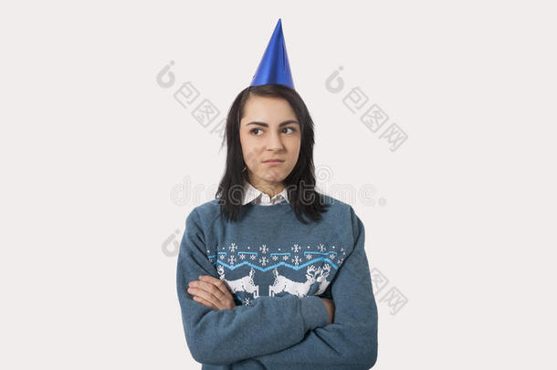 灰色背景下穿着圣诞套头衫和派对帽的妇女肖像