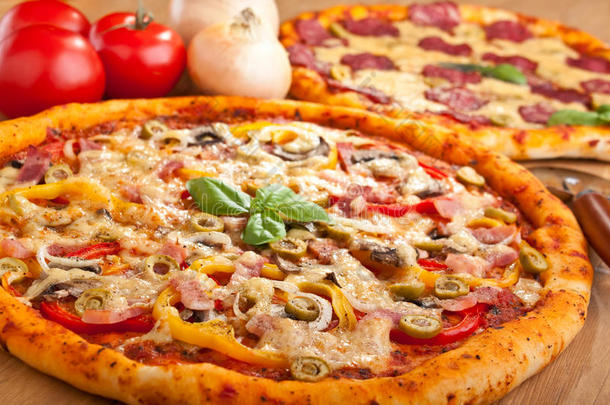 火腿蔬菜披萨，后面有萨拉米披萨
