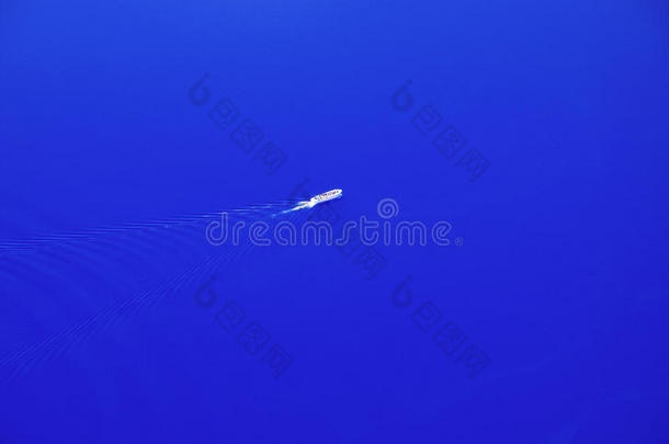 蓝色梦想-一艘快艇驶过平静的蓝色水域