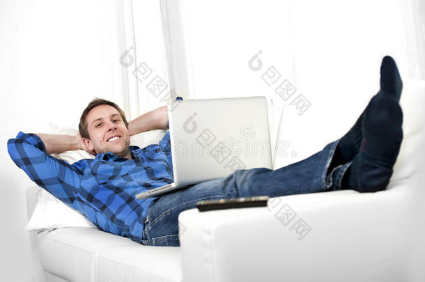有魅力的男人坐在沙发上玩电脑
