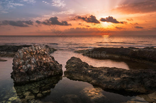 夕阳西下的大海和岩石海岸与古老的遗迹
