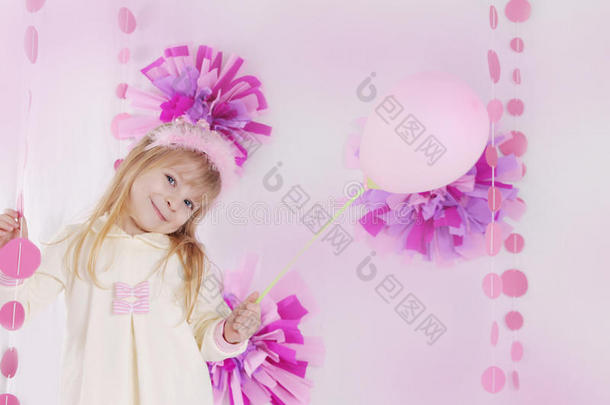 小女孩在粉红色装饰的生日聚会上用气球