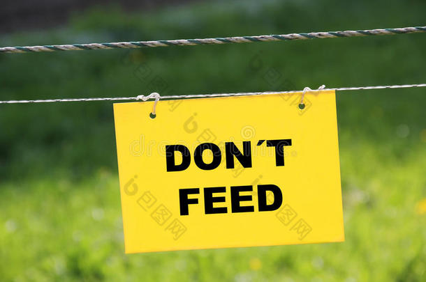 带有电气围栏和禁止标志的牧场-请勿喂食
