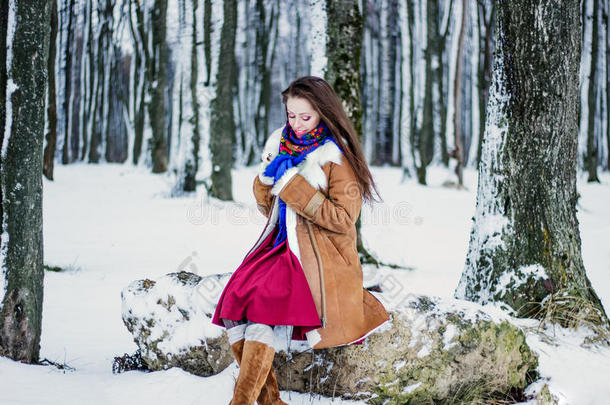 <strong>冬天</strong>森林里，一个穿着羊皮<strong>大衣</strong>的美女坐在树枝上