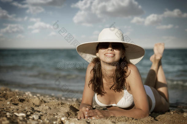 坐在日光浴床上晒日光浴的年轻女子。