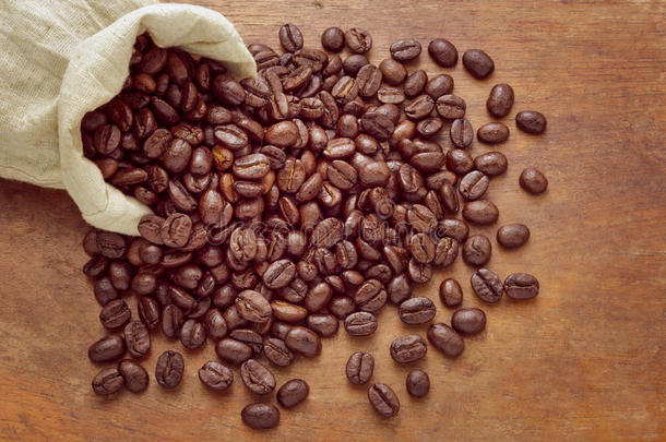 一袋咖啡豆<strong>放在</strong>肮脏的<strong>木质</strong>背景上。