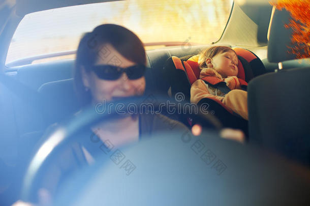 孩子坐在靠近母亲的安全座位上。