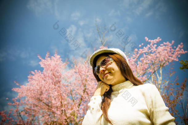 带着粉色樱花和蓝天的微笑女士