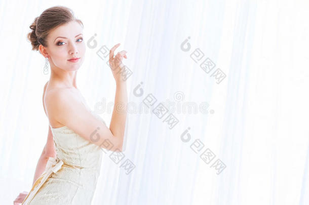 新娘穿着<strong>白裙</strong>子围着窗帘。