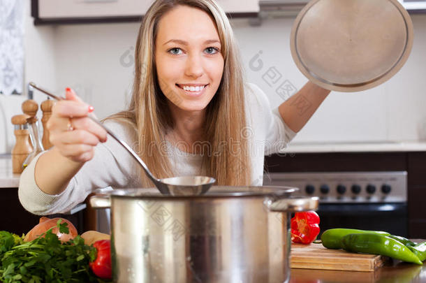 面带微笑的女孩拿着勺子<strong>煮汤</strong>