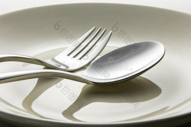 盘子上的金属勺子和叉子。