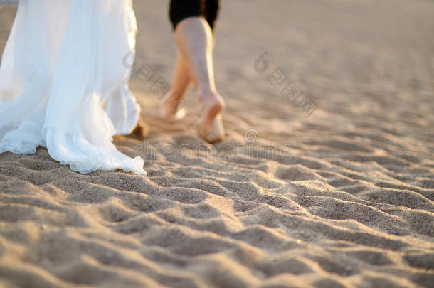 日落时的海滩上的新郎新娘