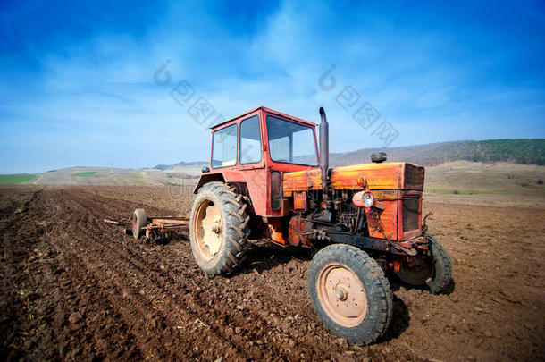 <strong>农民</strong>用拖拉机和犁在田里<strong>耕作</strong>
