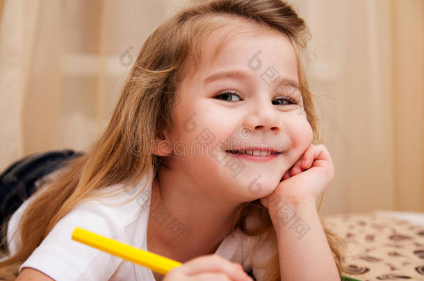 可爱的小女孩用铅笔画画。