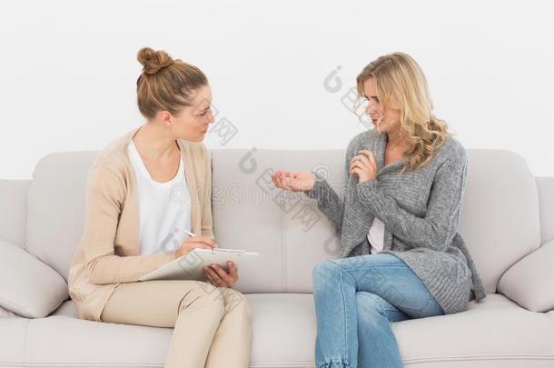 金发女人在沙发上和她的治疗师说话