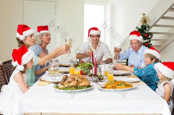 一家人在吃<strong>圣诞大餐</strong>的同时品尝葡萄酒