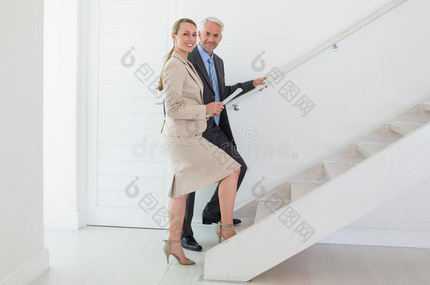 微笑的<strong>房产</strong>中介向潜在买家展示楼梯