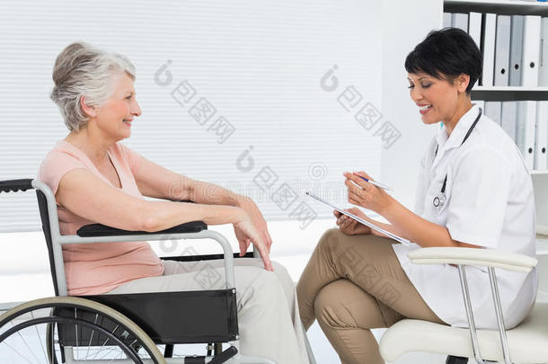 医生和一位坐在<strong>轮椅</strong>上的<strong>老年</strong>病人交谈
