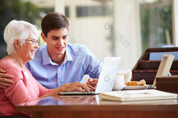 十几岁的孙子帮奶奶拿笔记本电脑