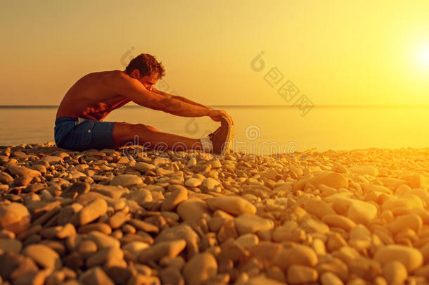 运动员练习，日落时在海滩上练瑜伽