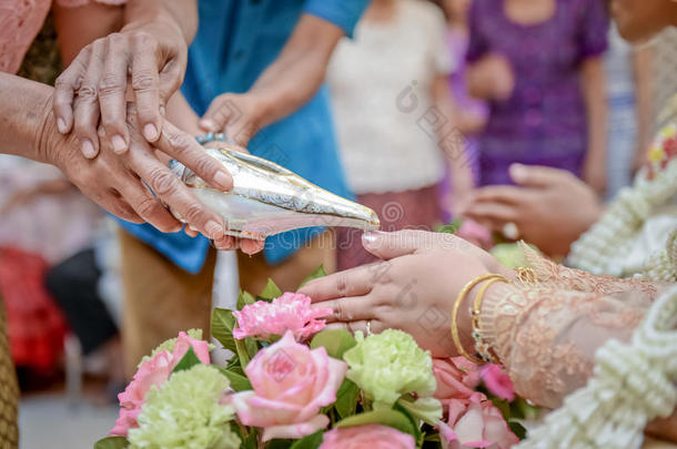 手把祝福水倒进新娘的手环里