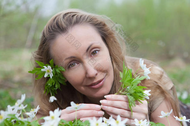 一个年轻美丽的女人在开满鲜花的雪地上